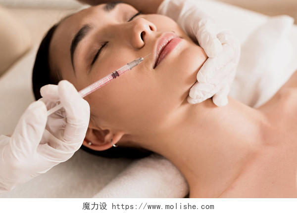 关闭有吸引力的亚洲妇女在诊所接受美容注射美容面部抗衰纹唇美容